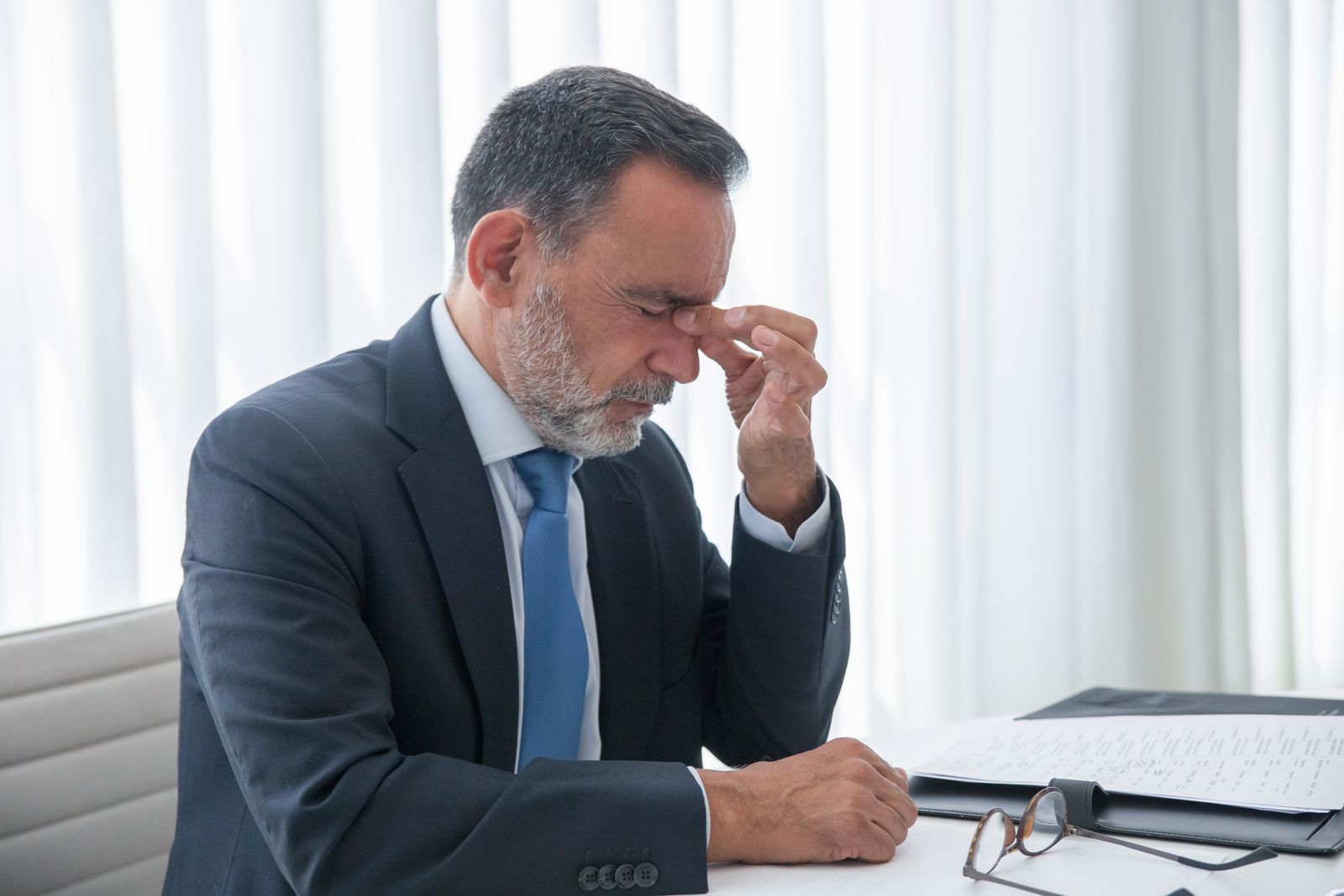 Burnout als Unternehmer: erschöpfter Geschäftsmann im Büro